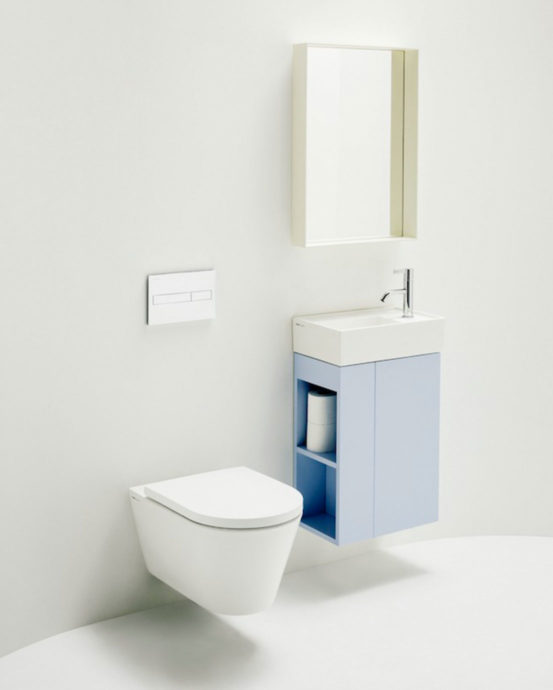 Novosan Laufen WC-istuin tilassa. Kuvassa valkoinen WC-istuin, allastaso, sininen allaskaappi ja peili.