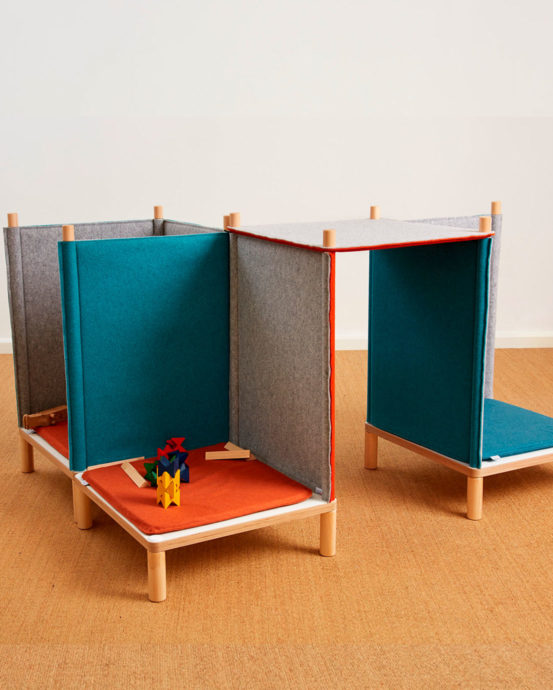 Novosan Timkid Sila-lastentuoliryhmä. Tuolien huopaseinät ovat harmaan, oranssin ja petrolin väriset. Yhdellä tuolilla on värikkäitä leikkipalikoita. Kahden tuolin välissä on huopakatto.