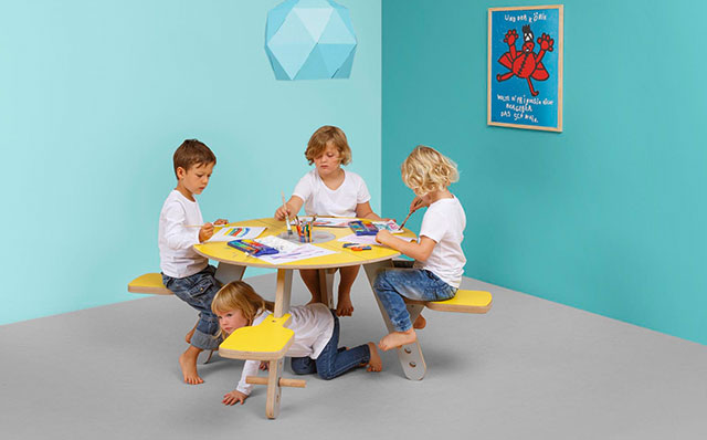 Novosan Timkid Tavi-pöytäryhmä. Lapset istuvat ja maalaavat vesiväreillä pyöreän pöydän ääressä. Pöydän väri: keltainen.