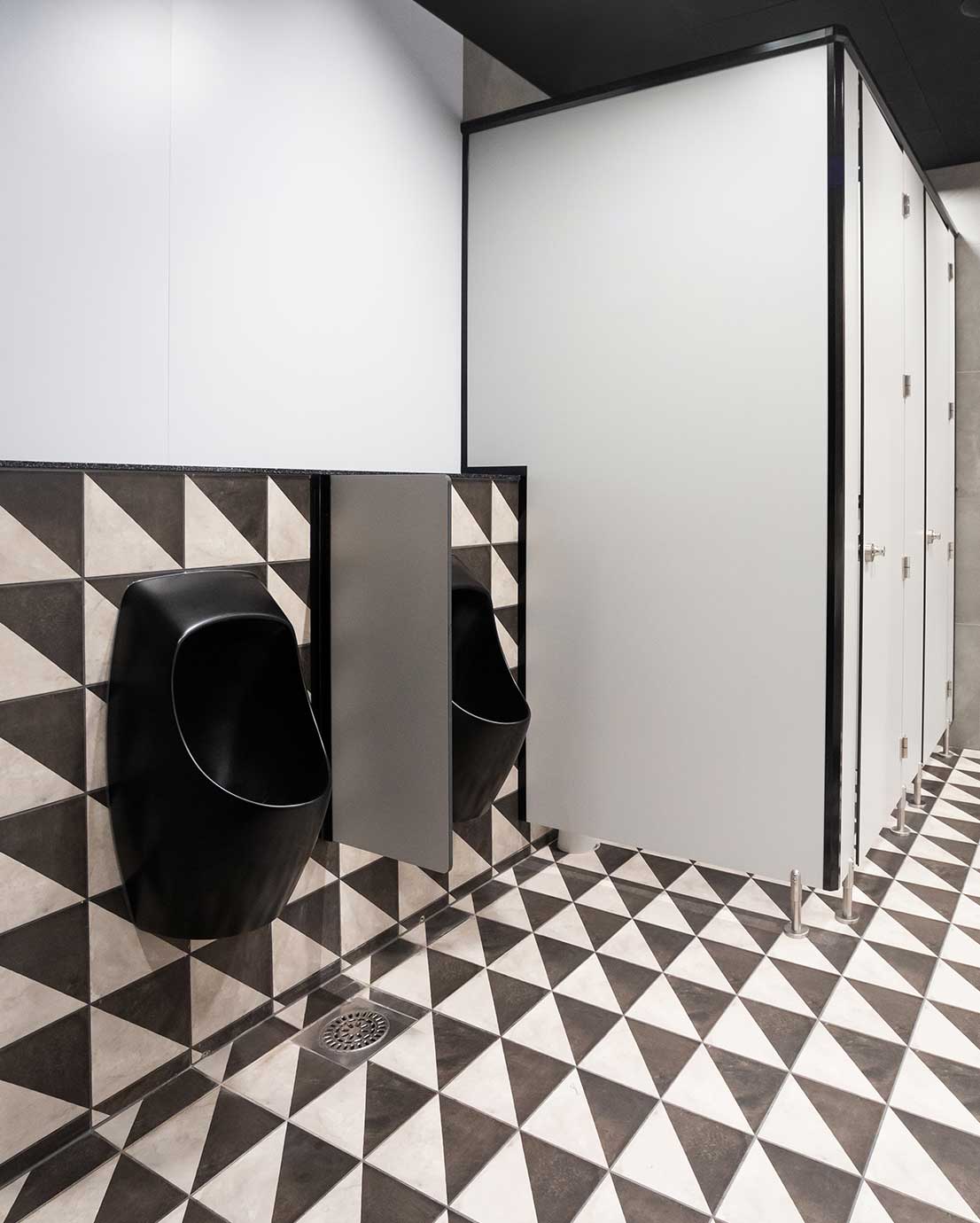 Mall of Tripla, miesten-WC:ssä on kaksi mustaa pisuaaria ja vaalea WC-koppi.