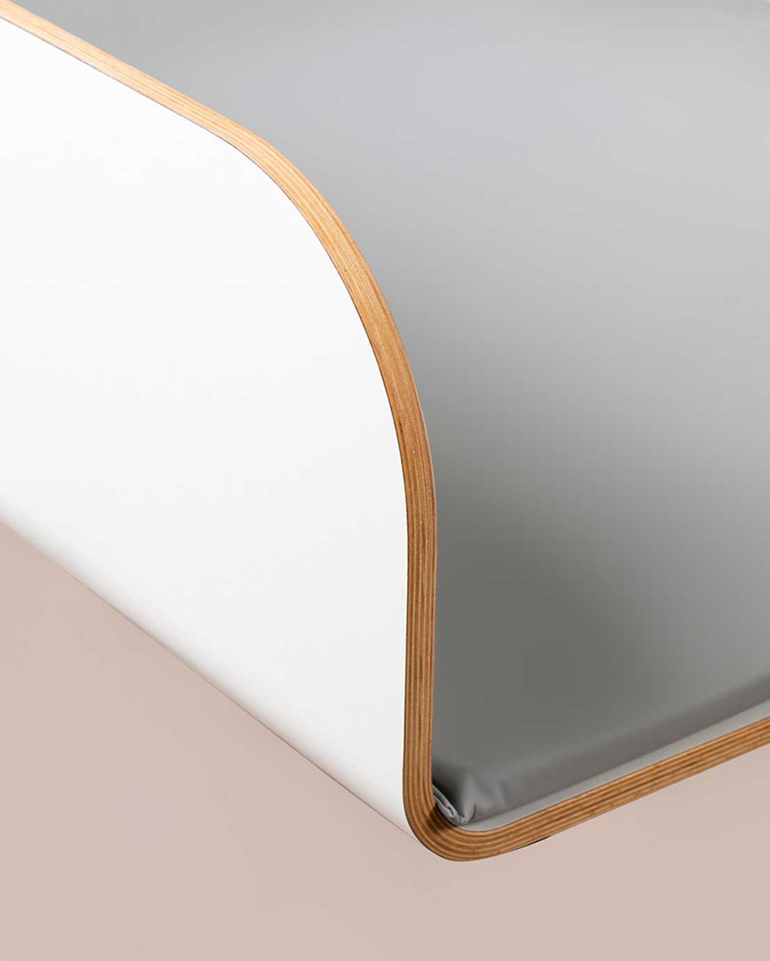 Novosan Timkid-hoitopöytä (lähikuva), jonka sisällä on harmaa hoitoalusta. Hoitopöydässä on korkeat, pyöristetyt ja turvalliset laidat.