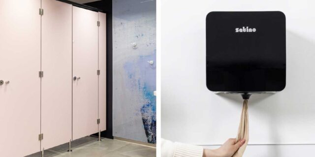 Naisten WC-tilassa vessakopit ja seinäkiinnitteinen musta käsipyyhepaperiannostelija